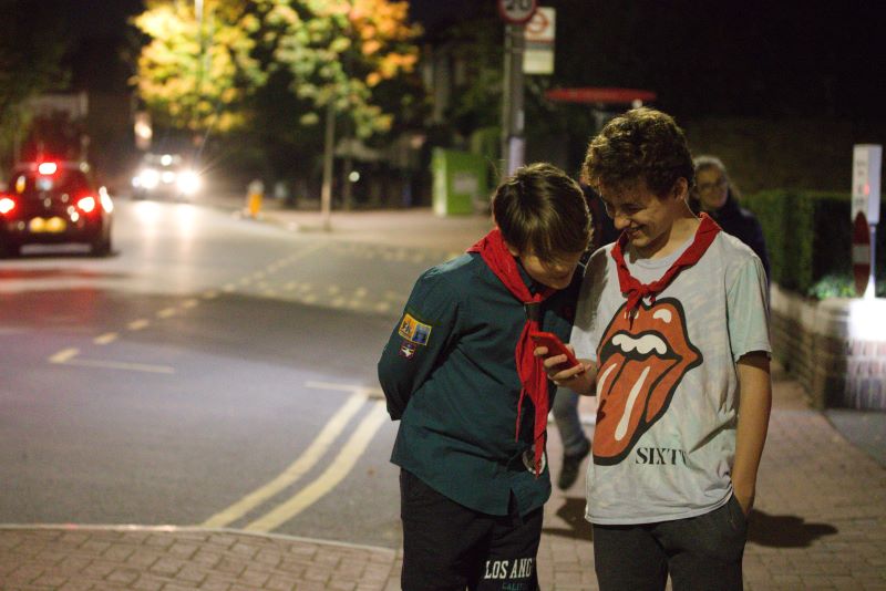 Scouts on pavement looking at phone