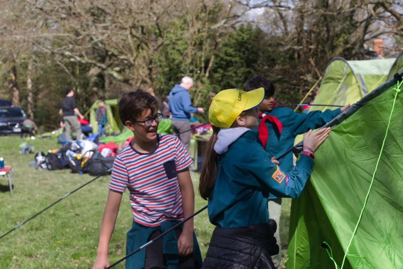 A picture of two scouts putting up a tent