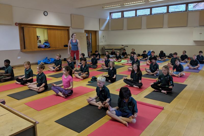 A picture of a cub meeting with the cubs sitting on yoga mats